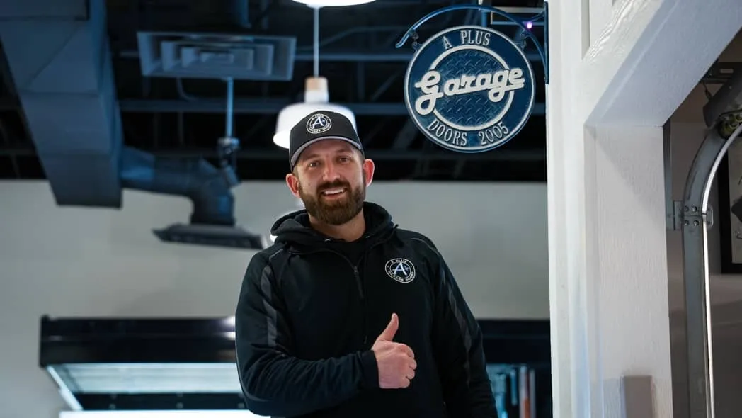 A Plus Garage Doors team member in showroom giving thumbs up