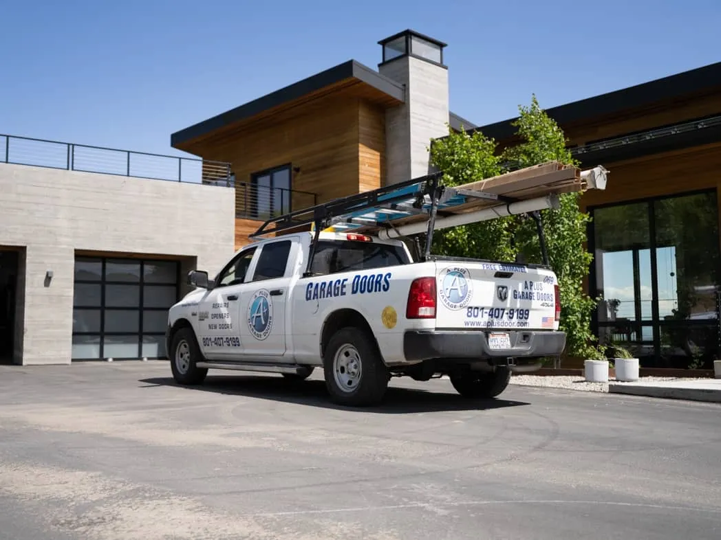 A Plus Garage Doors service truck at project site with visible A Plus Garage Door Repair branding