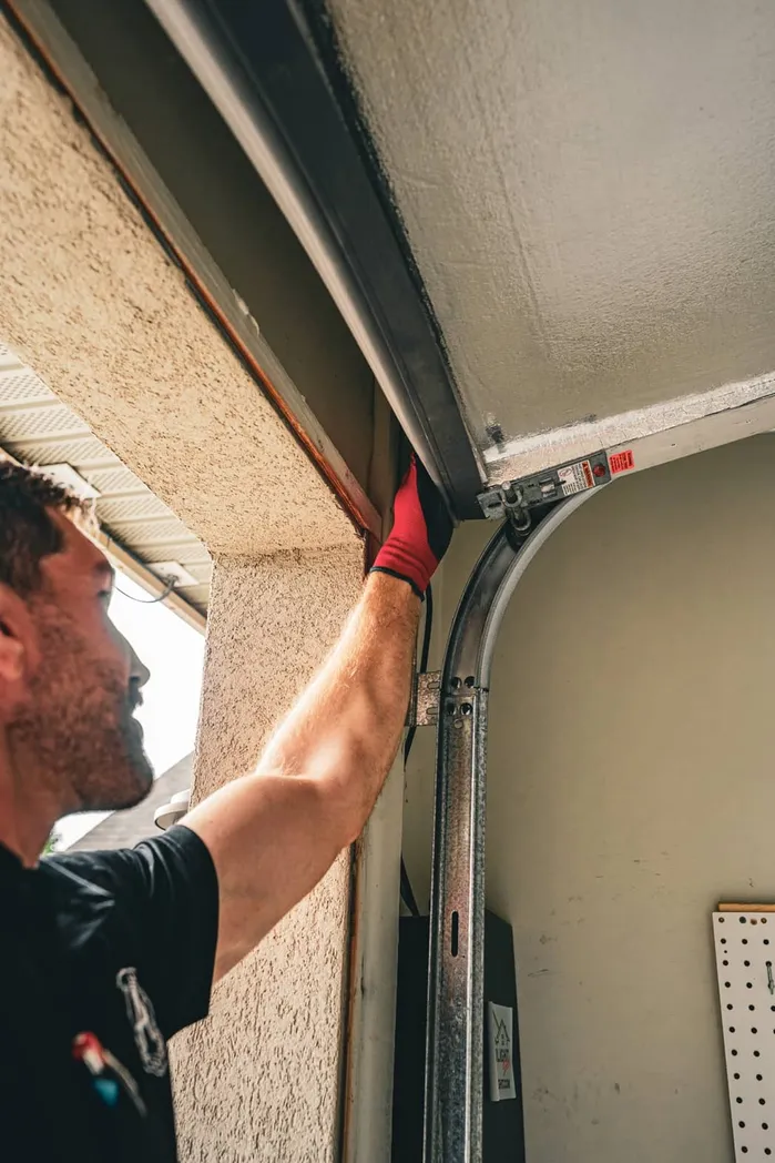 Technician adjusting commercial garage door mechanism