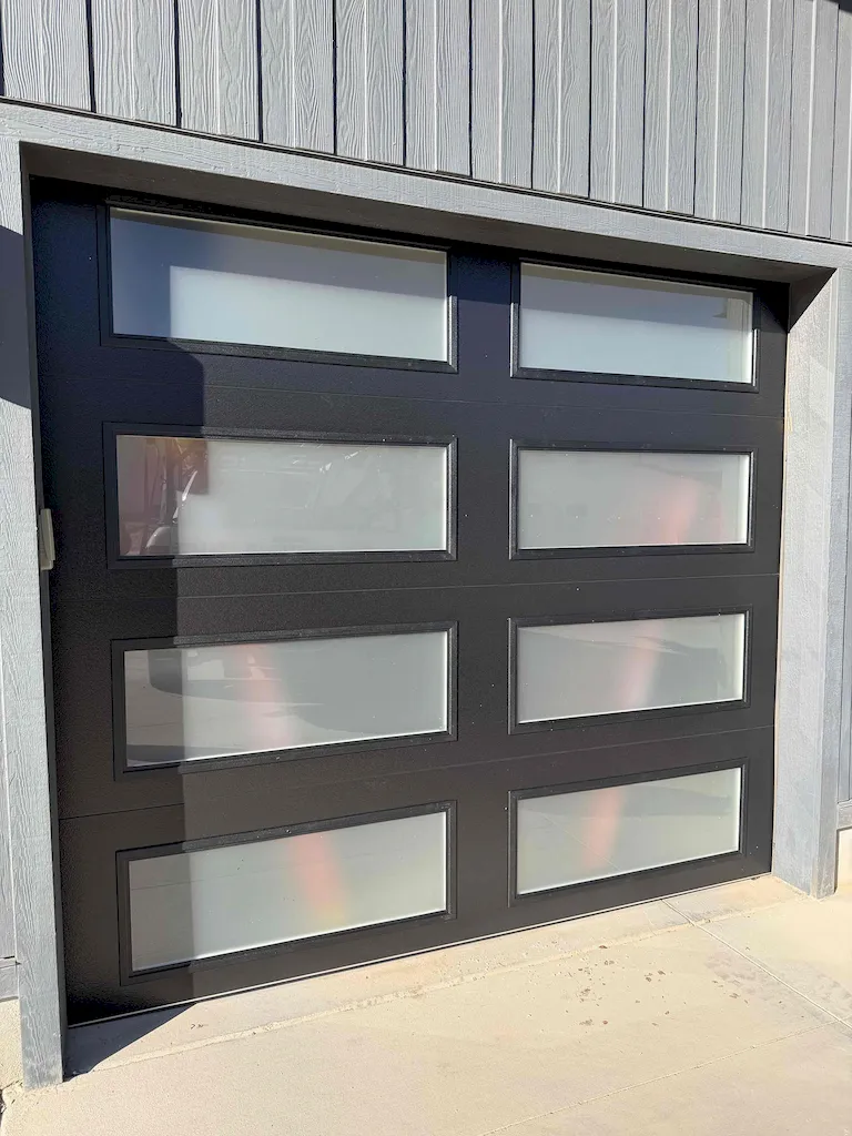 Contemporary home with two large glass garage doors
