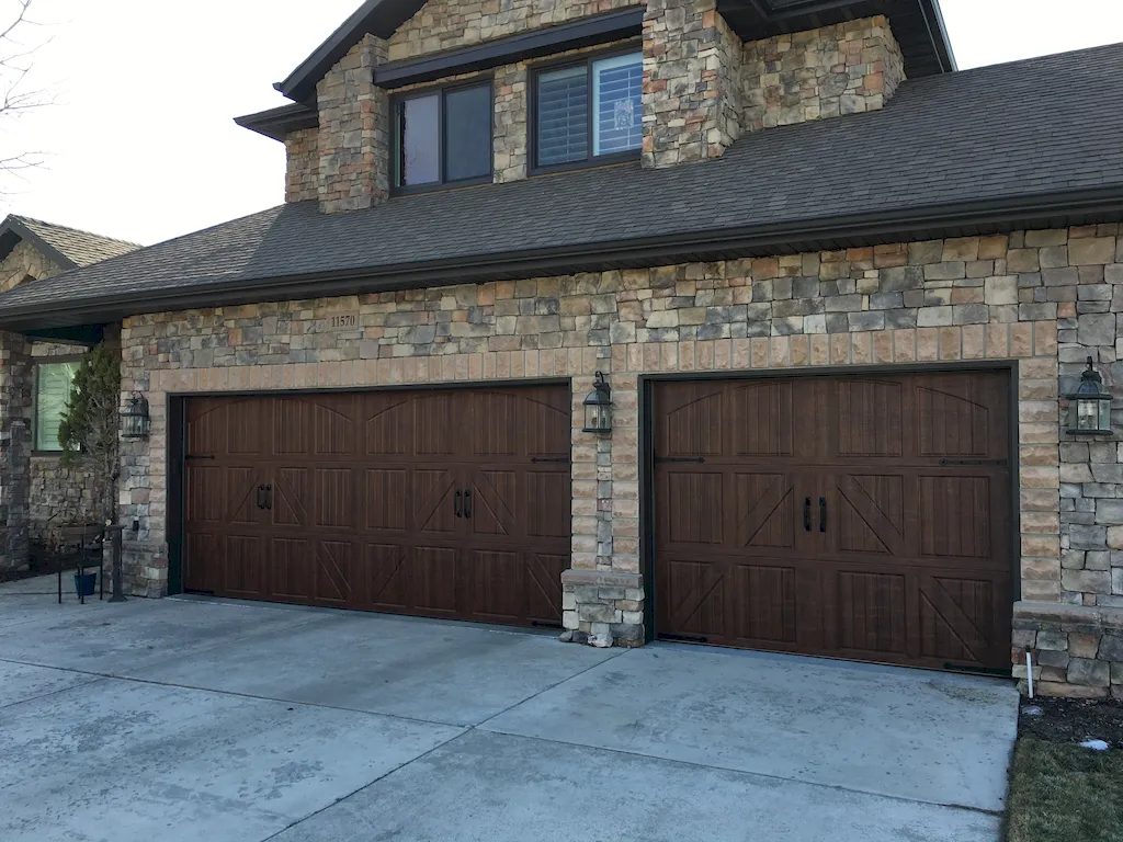 Upscale home with wood-look garage doors installed by A+ Garage Doors