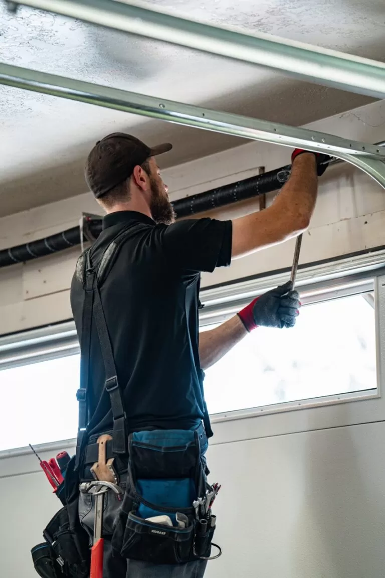 Technician Repairing a Garage Door Torsion Spring | What You Should Know About Your Garage Doors Torsion Springs | A Plus Garage Doors | Garage Door Tension Springs